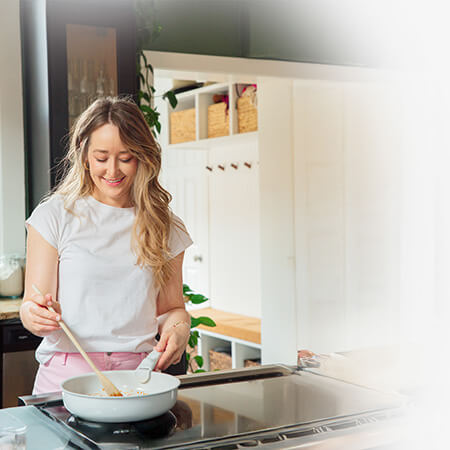 Sarah Bond stirring ingredients in a white pan.